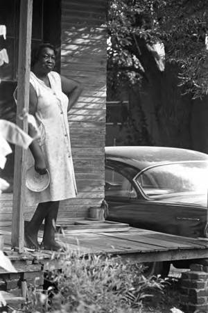 Woman standing on a front porch, observing the "March Against Fear" through Mississippi, begun by James Meredith.