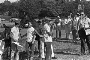 Group of white people standing beside a paved road, observing the "March Against Fear" through Mississippi, begun by James Meredith.