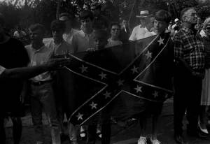 Group of young white boys holding up a Confederate flag by the side of a road, while observing the "March Against Fear" through Mississippi.