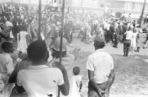 Adults and children seated on a porch, observing the "March Against Fear" through Mississippi, begun by James Meredith.