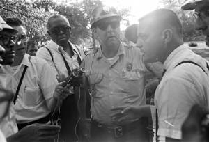 Man speaking to marchers and Mississippi Highway Patrol officers during the "March Against Fear" begun by James Meredith.