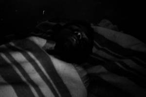 Man lying down indoors at a rest stop during the "March Against Fear" through Mississippi, begun by James Meredith.