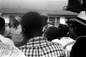 Police officers in Jackson, Mississippi, speaking to a crowd on a street in a neighborhood during the "March Against Fear" begun by James Meredith.