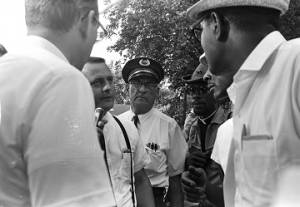 Man speaking to marchers and Mississippi Highway Patrol officers during the "March Against Fear" begun by James Meredith.
