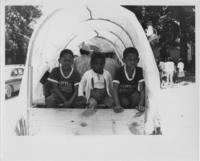 Three Young Boys Riding in the Back of a Wagon, circa 1968