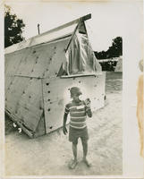 A Young Boy Drinking Out of a Can in Front of a Wooden Tent in Resurrection City, 1968
