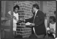 Joseph E. Lowery Handing a SCLC Flier to a Resident, circa 1983