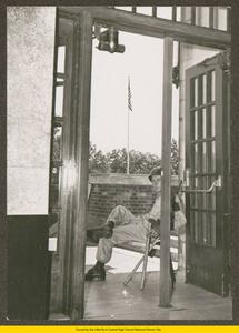 National Guardsman seated outside of a door