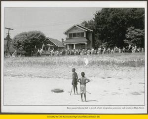 Two black children watch segregationist marchers
