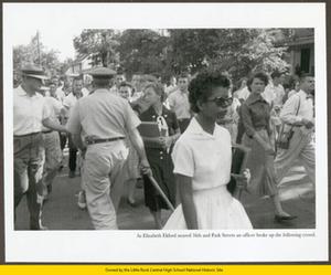 Police restrain hecklers following Elizabeth Eckford