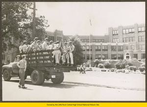 Young white male talking to National Guard troops on back of truck