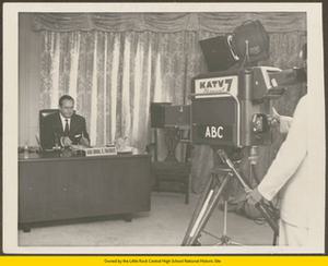 Orval Faubus seated at desk in front of KATV 7 television camera