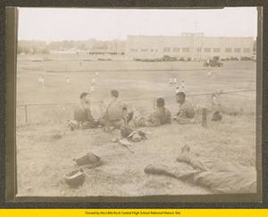 Four soldiers watching girls' soccer game