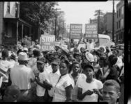 Crowd, including Greta Richardson fourth from the right, holding signs "Andy Jackson need not have died" and "Detour, Speedway closed for lack of lights and police protection," blocking traffic in street