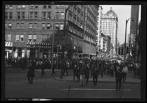 Crowd of people walking towards entrance to Point State Park, with Thrift Drugs, Kappels Jewelers, and First Federal of Pittsburgh in background