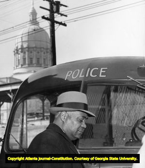 Reverand William Holmes Borders being arrested by police after staging a segregation bus protest, 1957