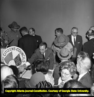 Governor George Wallace speaks to supporters while demonstrations against him rally outside, 1963
