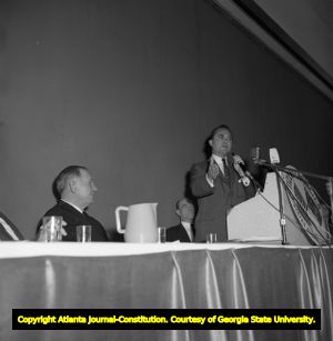 Governor George Wallace speaks to supporters while demonstrations against him rally outside, 1963