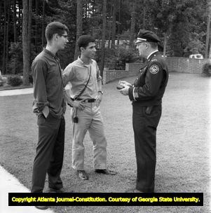 Police officer speaking with two white students at Northside High School (later North Atlanta High School) on the day of its racial integration, Atlanta, Georgia, August 30, 1961.