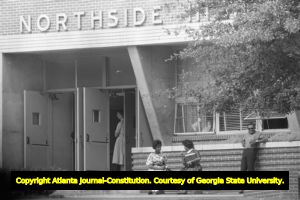 Three African American students waiting to picked up from Northside High School (later North Atlanta High School) on the first day of its racial integration, Atlanta, Georgia, August 30, 1961.
