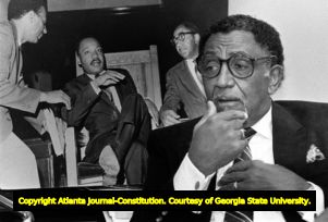 Reverand Joseph Lowery sitting in front of historical photo, 1986
