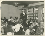 Man stands to speak at a meeting