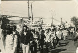 Protesters march with banners, "Racism is the Enemy of all poor & working people [xx]sh the Klan"