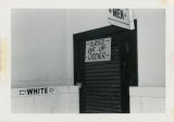 White-only men's restroom with sign, "Closed Out of Order".