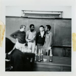 Four men standing at the front of a classroom