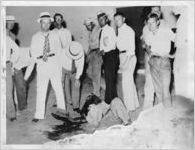 Injured African American longeshoreman surrounded by white males during dock workers' strike, Houston, Texas, July 17, 1934