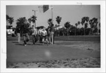 Ethnically diverse group of young boys playing basketball on a public court