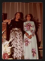 [Rosa Parks, wearing blue dress with floral print, at a formal event, standing with another woman] [graphic].