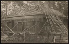 [Photograph showing a house under construction and worker standing at site, probably in Alabama] [graphic].