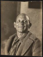[Unidentified man, head-and-shoulders portrait, seated, facing front, smiling] [graphic].