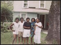 [Five women, standing in yard in front of house, posing together near large tree] [graphic].