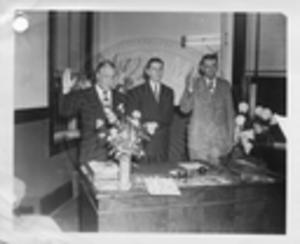 Gartin with two unidentified men being sworn in