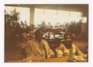 Photograph of Unidentified Persons Sitting at Dining Table