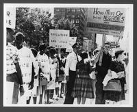 Black civil rights activists march while segregationists protest